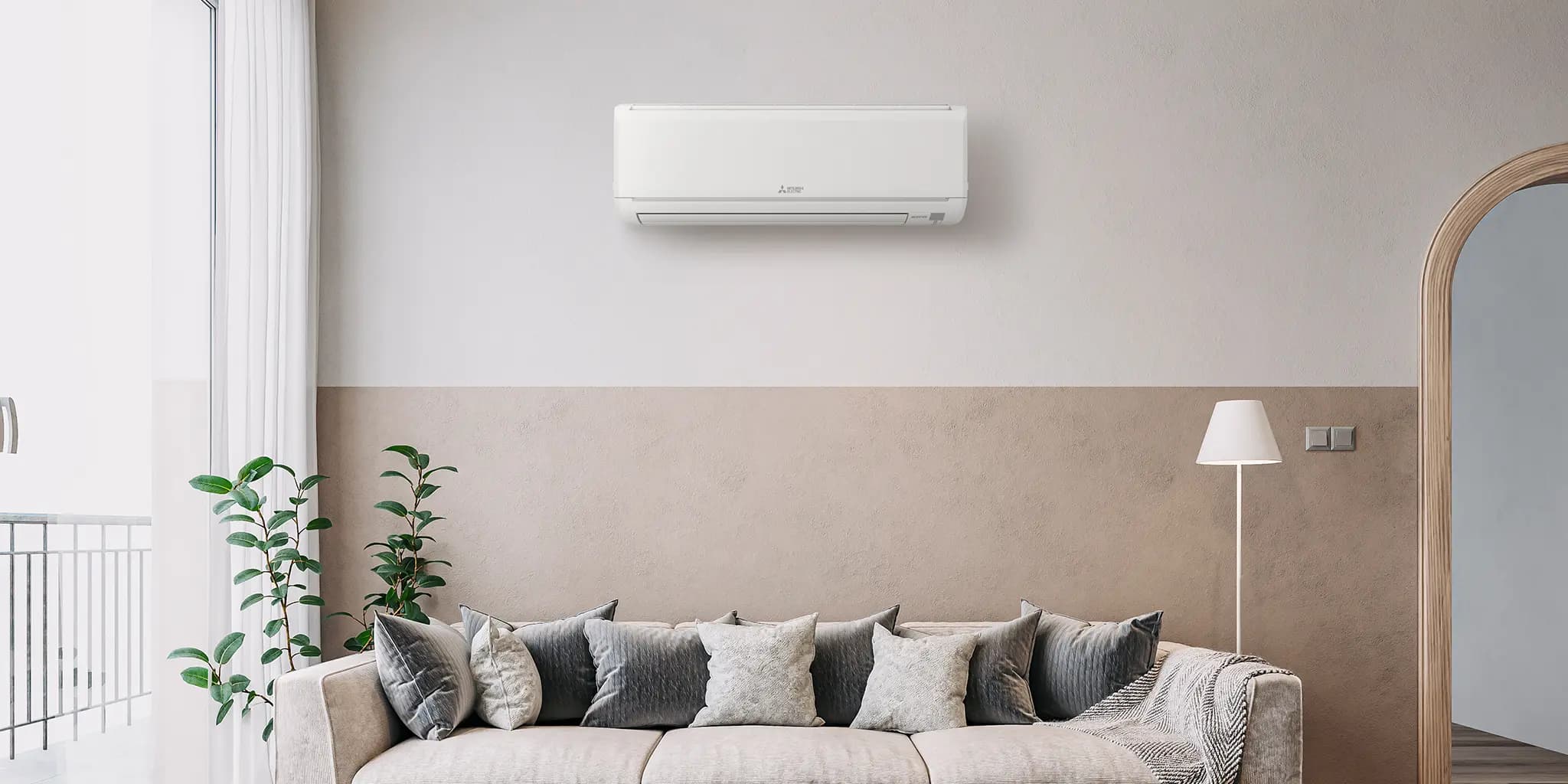Ductless indoor mini-split unit mounted above a living room sofa