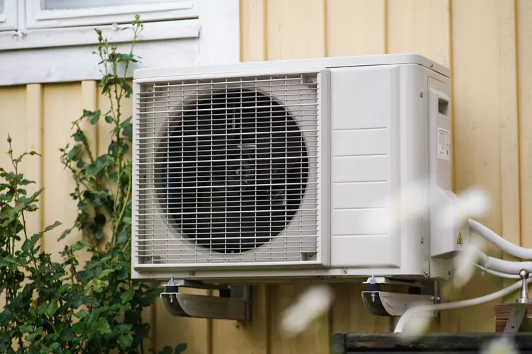 Outdoor condenser unit mounted on an exterior wall